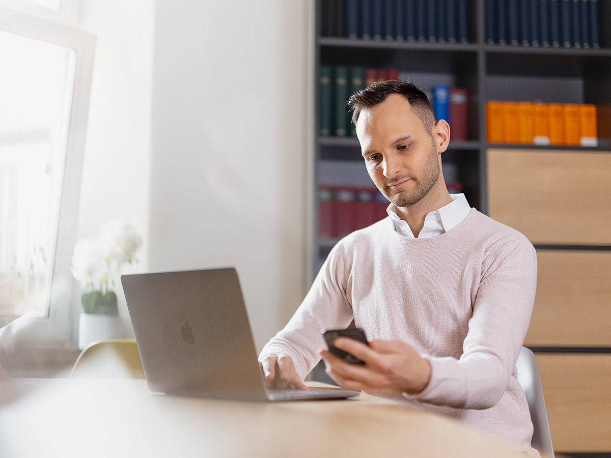 Steuerberater Sebastian Fischer bei der digitalen Betreuung von Heilberufen am Laptop und Smartphone