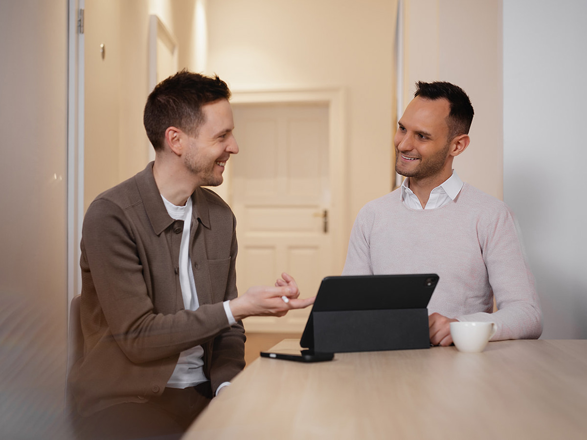 Michael Fürgut und Sebastian Fischer beraten sich im Büro am Tablet zur Steuerberatung für digitale Unternehmen